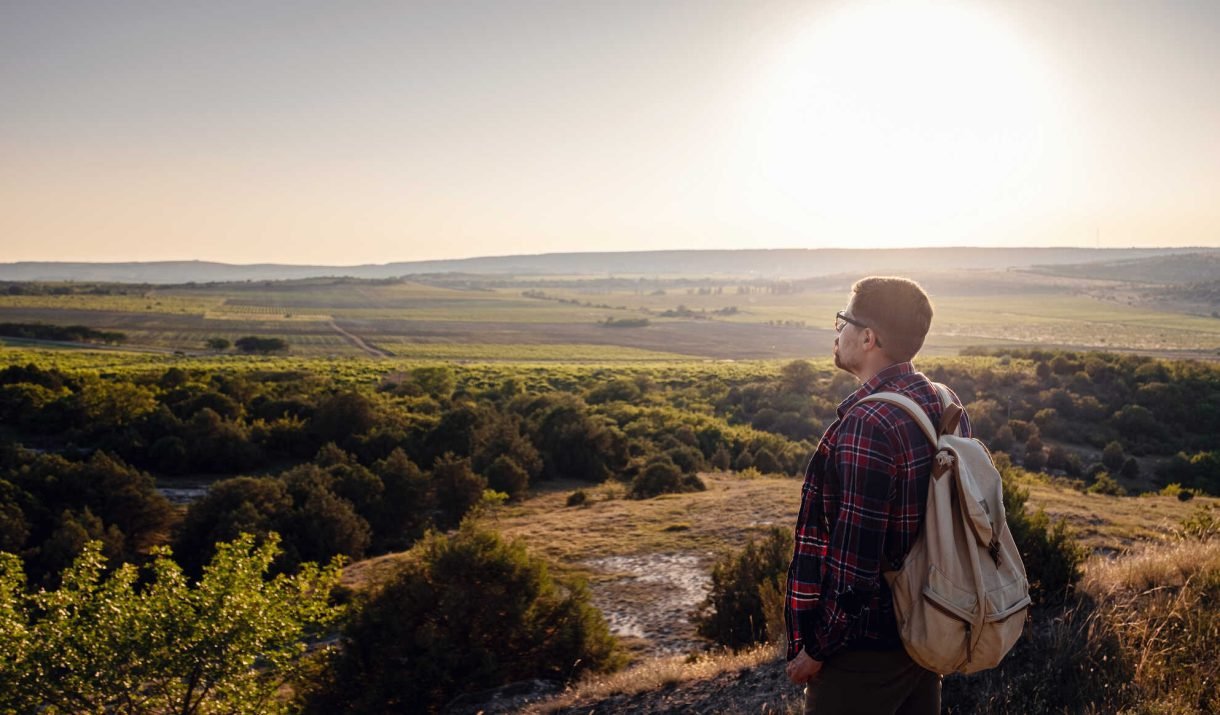 a man standing on a mountain as the sun sets 2023 11 27 05 15 05 utc easy resize.com