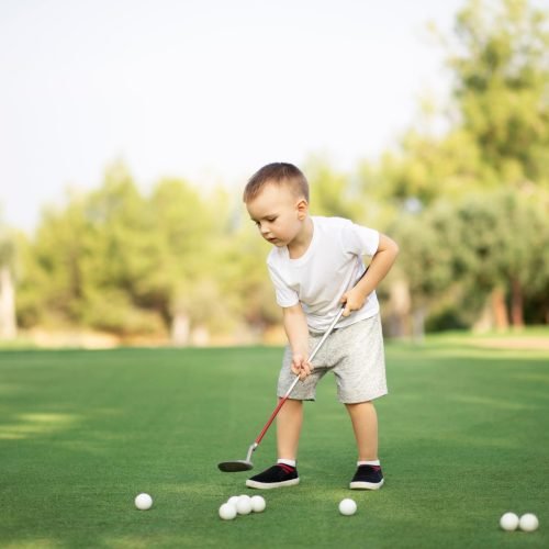 little boy playing golf with golf club on green fi 2023 11 27 05 34 35 utc.jpg